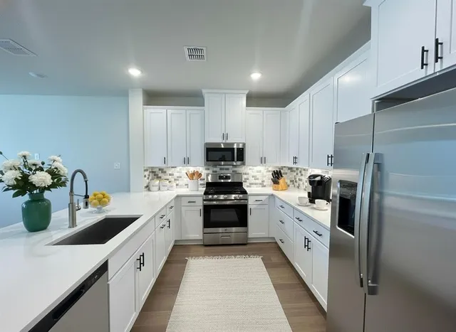 a kitchen with sink a stove and refrigerator
