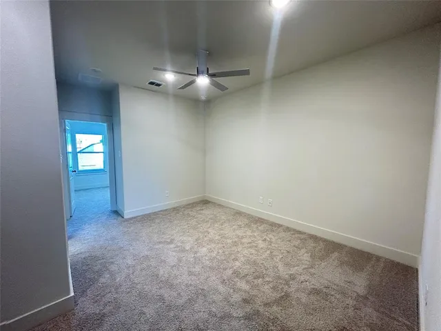 an empty room with closet and fan