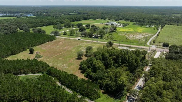 an aerial view of residential houses with outdoor space and trees