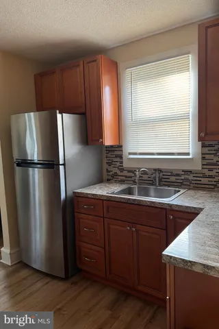 a kitchen with granite countertop a refrigerator and a sink