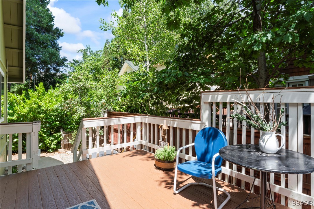 371 Maple Drive Lake Arrowhead, CA 92352 - Photo 34 of 50 a view of a patio with table and chairs potted plants with wooden floor and fence