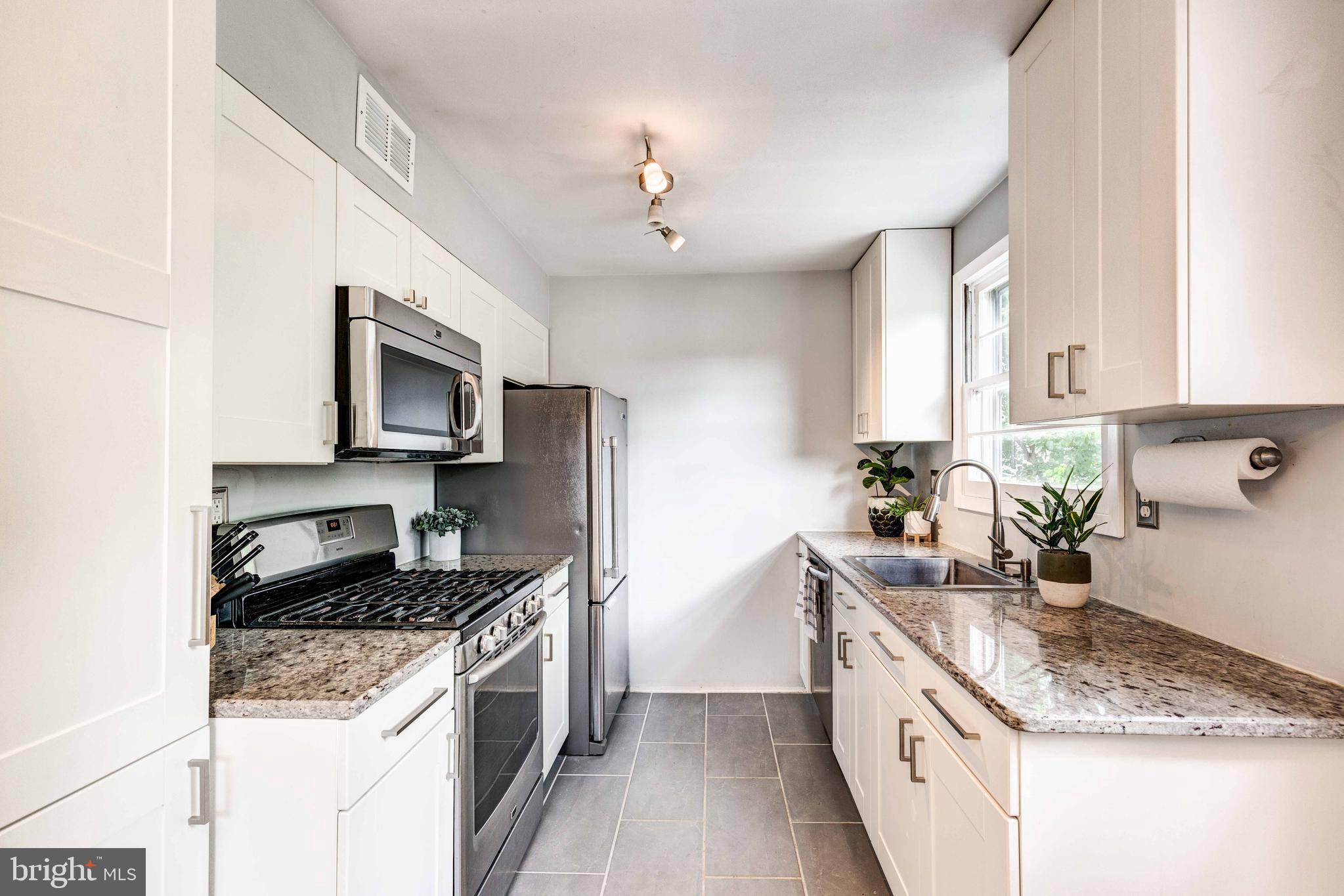 802 Templecliff Road Baltimore, MD 21208 - Photo 14 of 30 a kitchen with granite countertop a sink stainless steel appliances and white cabinets