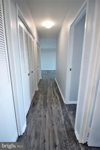 a view of a hallway with wooden floor