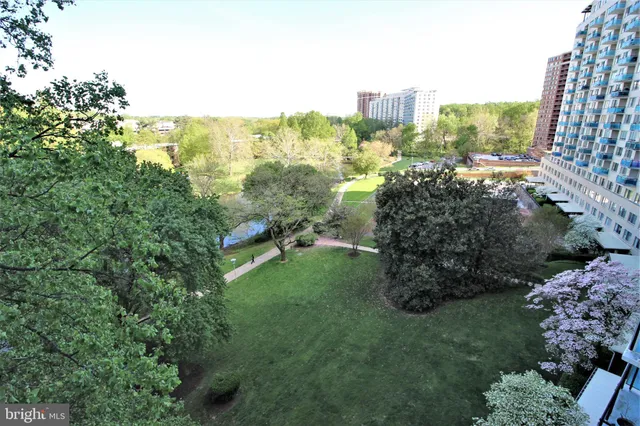 a garden with tall buildings in the background