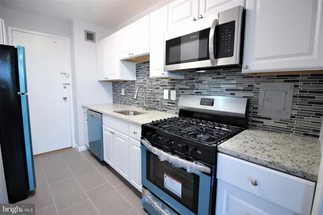 a kitchen with stainless steel appliances granite countertop a stove microwave and sink