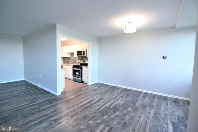 a view of a kitchen with wooden floor and a window