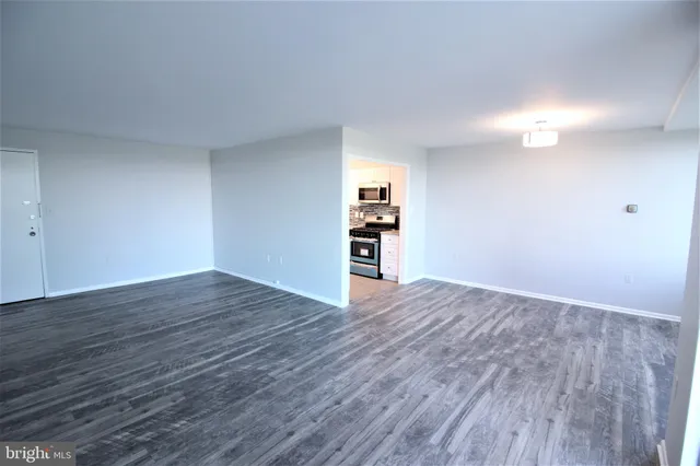 a view of empty room with wooden floor
