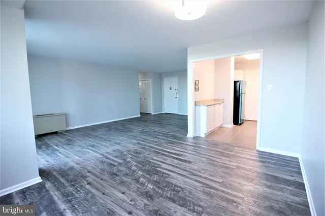 a view of empty room with wooden floor and window