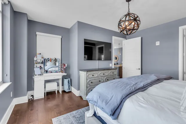 a bedroom with a bed and a chandelier