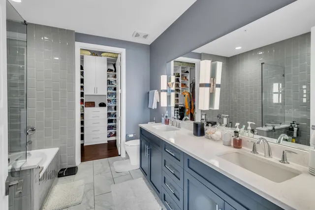 a spacious bathroom with a double vanity sink a large mirror and shower