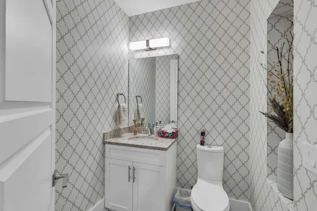a bathroom with a sink mirror vanity and toilet