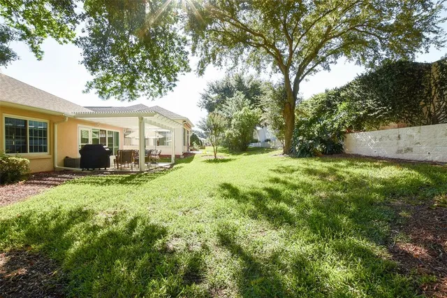 a view of a house with backyard and a tree