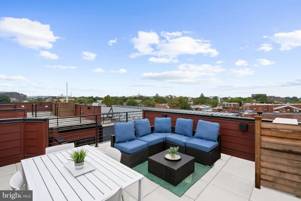 a view of a roof deck with couches and potted plants