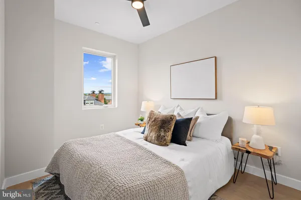 a bedroom with a bed and a lamp on dresser