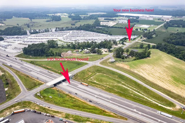 an aerial view of a tennis ground and a cars park side of a road