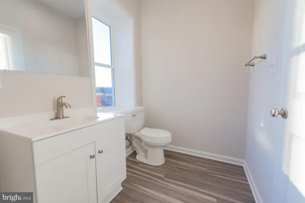 a bathroom with a sink a toilet and a window