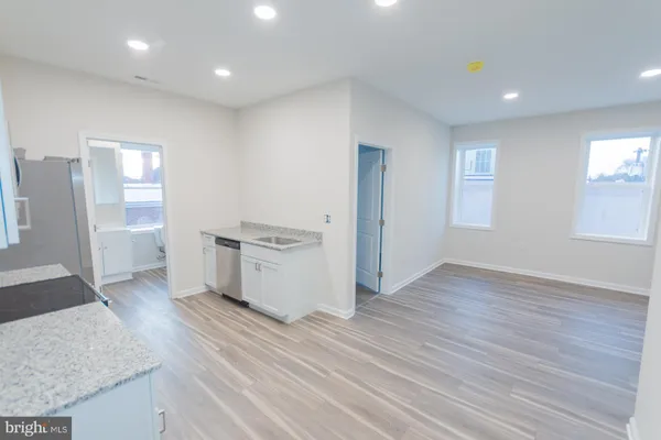 an empty room with wooden floor and cabinet