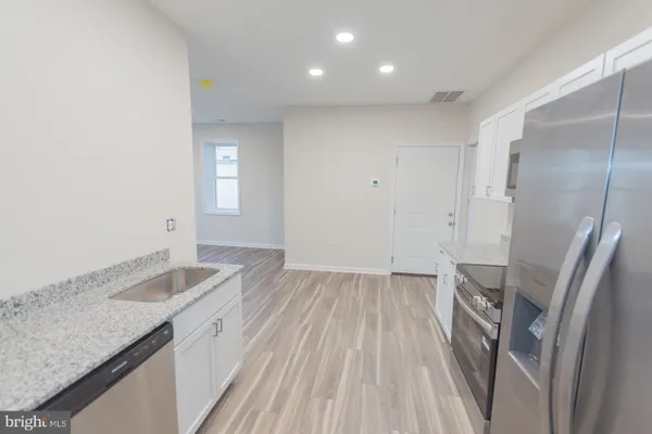 a kitchen with granite countertop a sink and a stove top oven