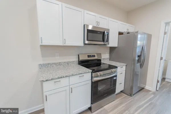 a kitchen with white cabinets stainless steel appliances and sink