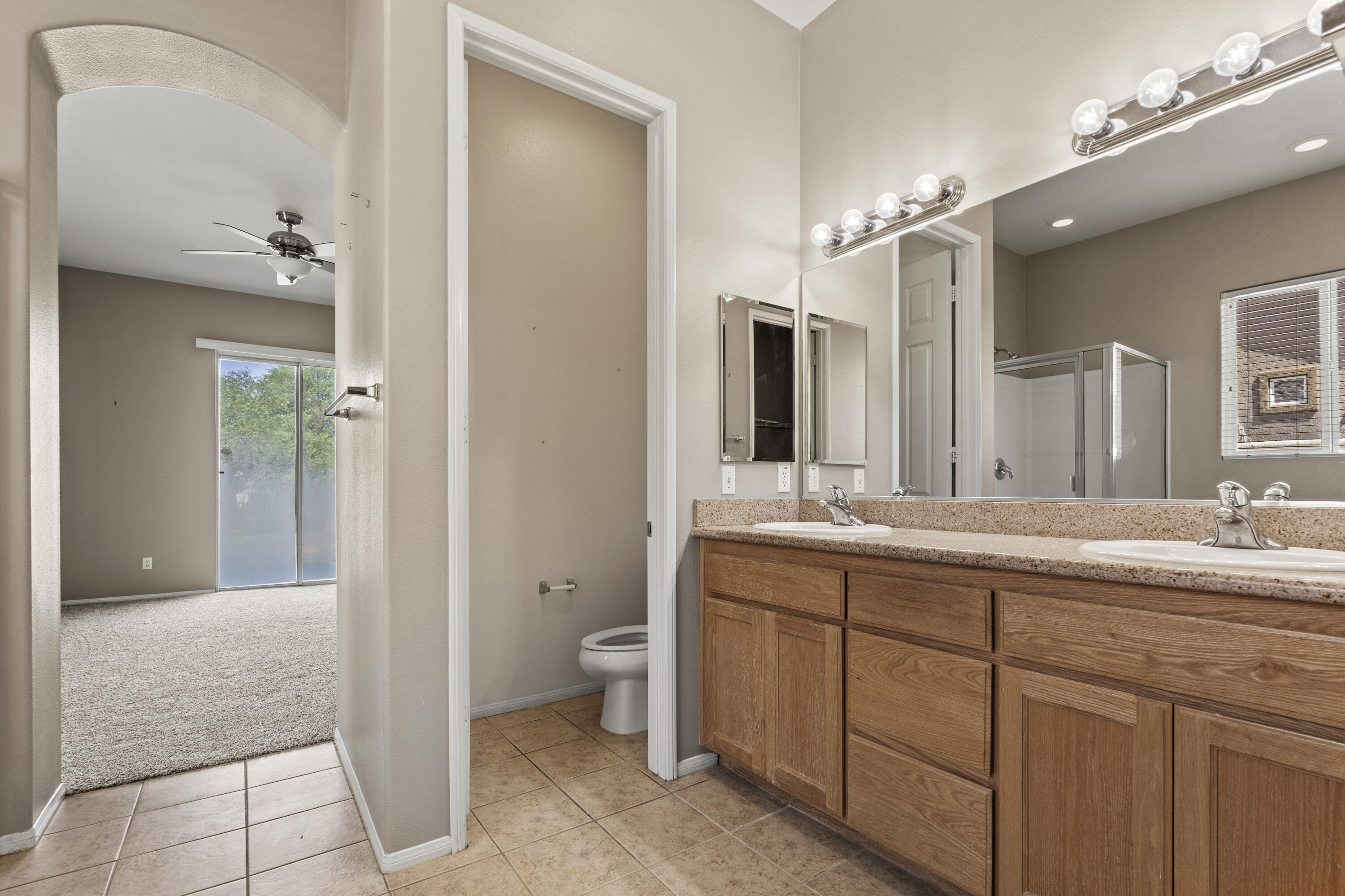 49418 Wayne Street Indio, CA 92201 - Photo 17 of 29 a spacious bathroom with a granite countertop sink a toilet and a mirror