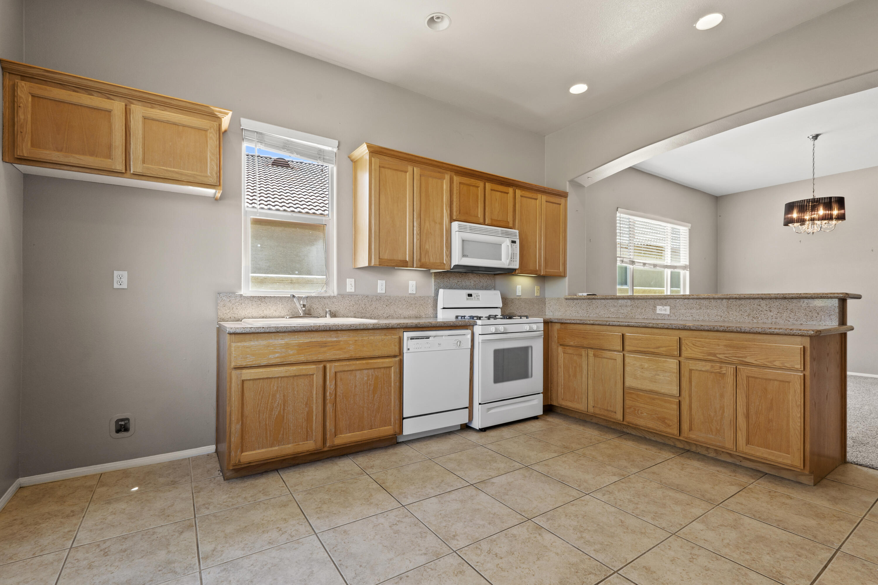 49418 Wayne Street Indio, CA 92201 - Photo 23 of 29 a kitchen with granite countertop cabinets and white appliances