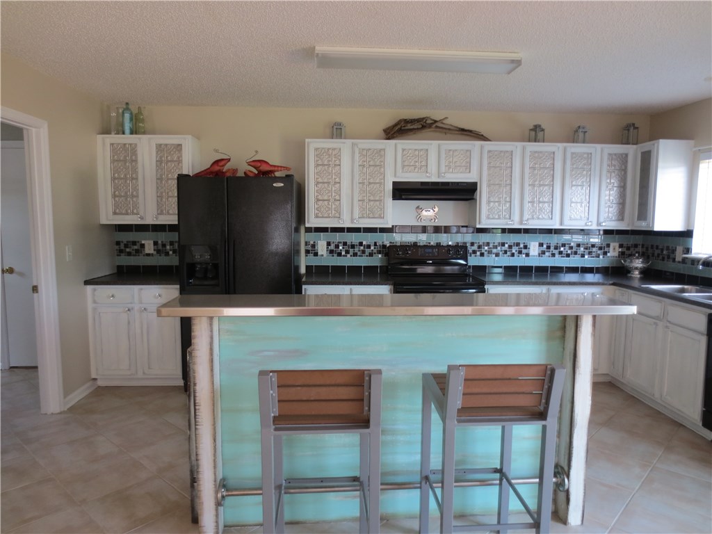 86063 Augustus Avenue Yulee, FL 32097 - Photo 8 of 20 a kitchen with stainless steel appliances granite countertop a stove a sink a microwave a refrigerator and cabinets