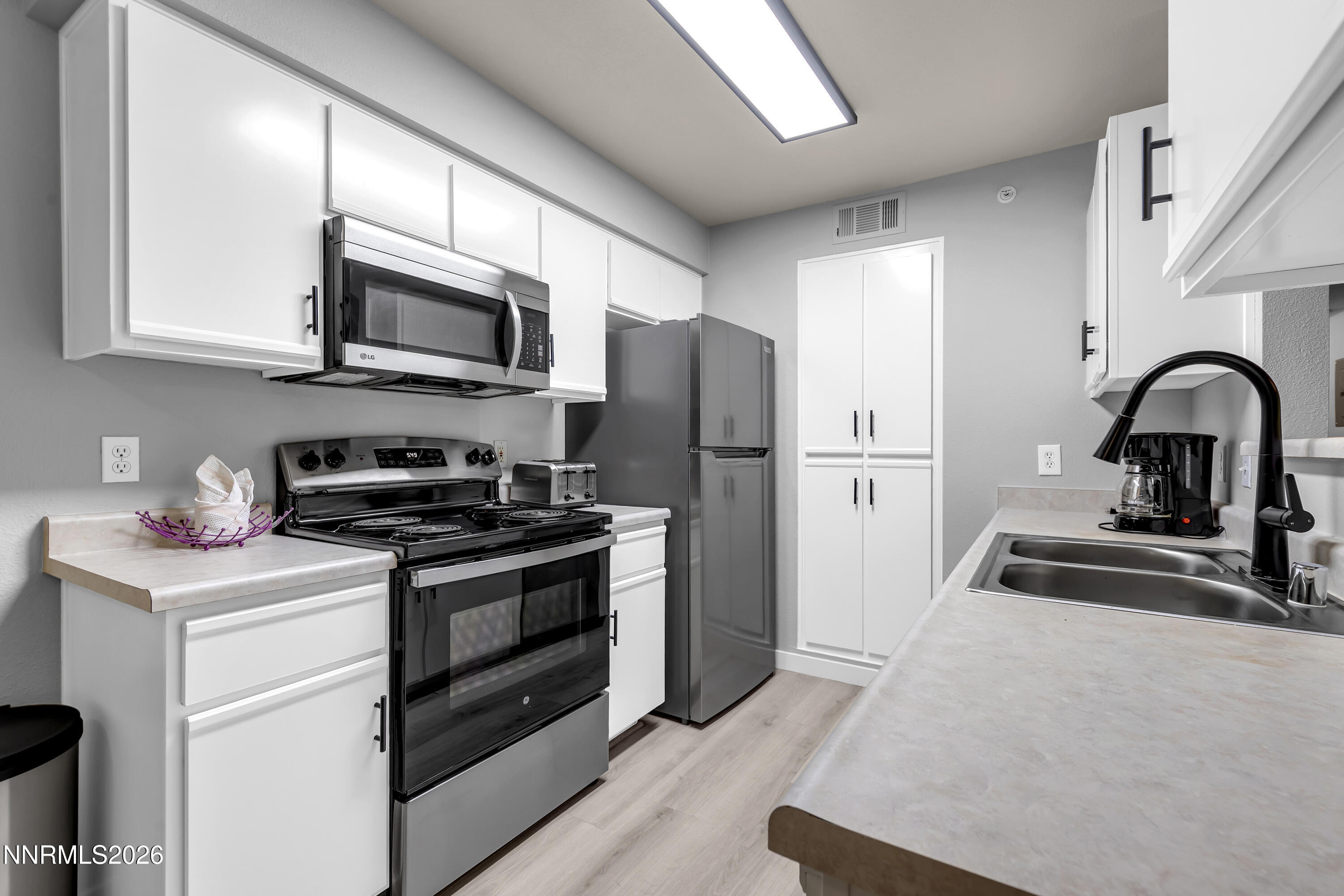 6850 Sharlands Avenue, Unit E 2022 Reno, NV 89523 - Photo 13 of 19 a kitchen with stainless steel appliances granite countertop a sink stove and refrigerator