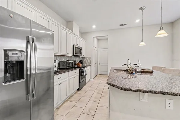 a kitchen with granite countertop a sink appliances and cabinets