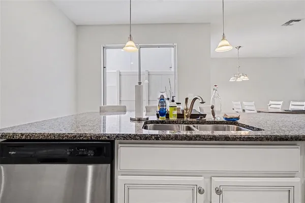 a kitchen with granite countertop stainless steel appliances a sink and a counter space