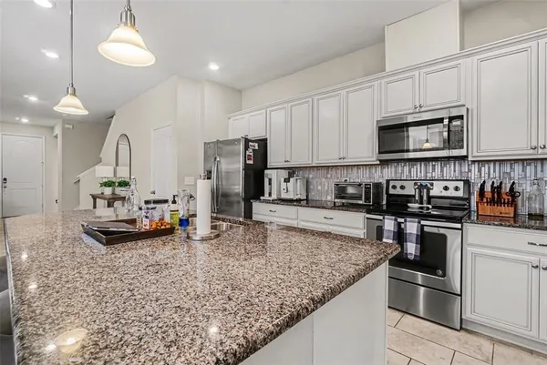 a kitchen with stainless steel appliances granite countertop a sink refrigerator and microwave