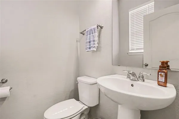 a bathroom with a sink a toilet and a mirror