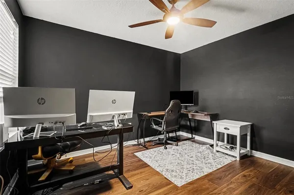 a living room with a piano and a printer next to a window