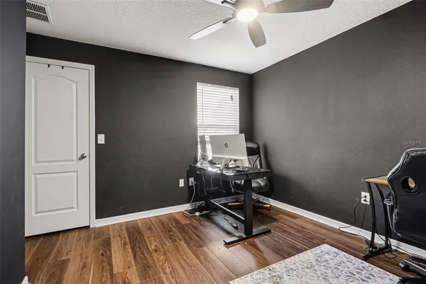 a view of a workspace with furniture and a window