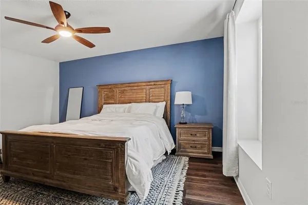 a bedroom with a bed and a ceiling fan
