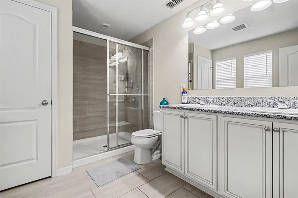 a bathroom with a granite countertop sink toilet and shower