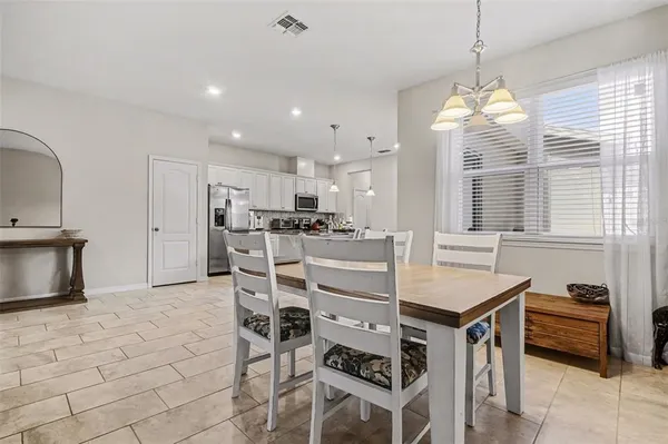 a kitchen with stainless steel appliances kitchen island granite countertop a sink and a refrigerator