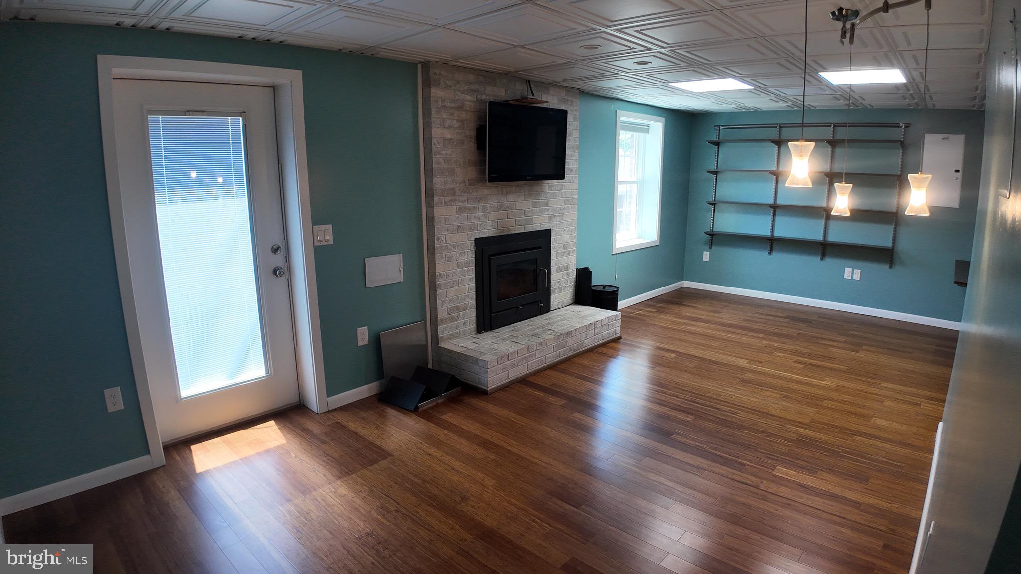 1185 Kesler Road Front Royal, VA 22630 - Photo 14 of 51 an empty room with wooden floor fireplace and windows