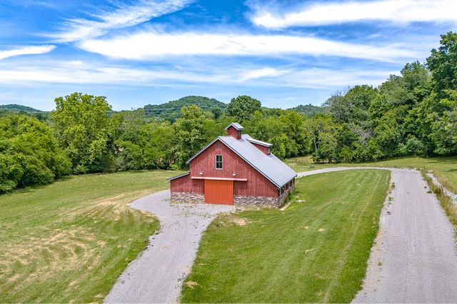 a house with green field in front of it