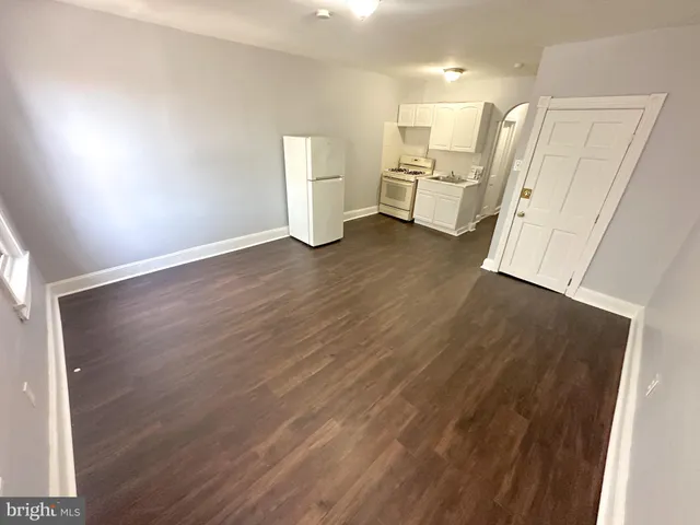 a view of a kitchen with furniture and wooden floor
