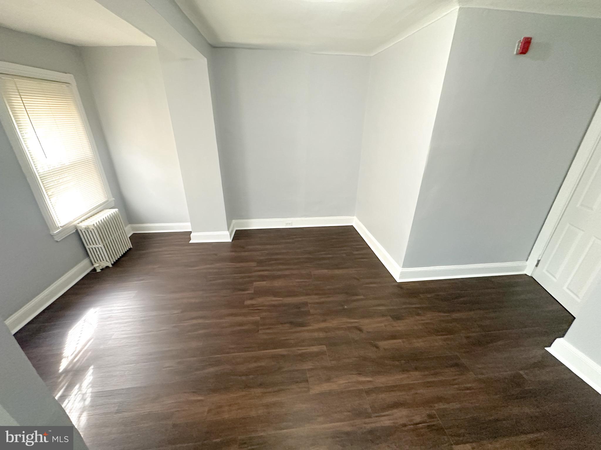 2321 North 25th Street, Unit 2 Philadelphia, PA 19132 - Photo 6 of 9 an empty room with wooden floor and windows