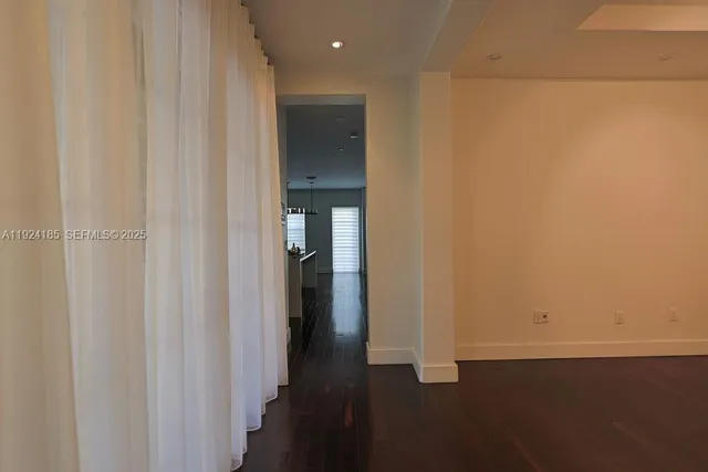 a kitchen with a sink a refrigerator and wooden floor