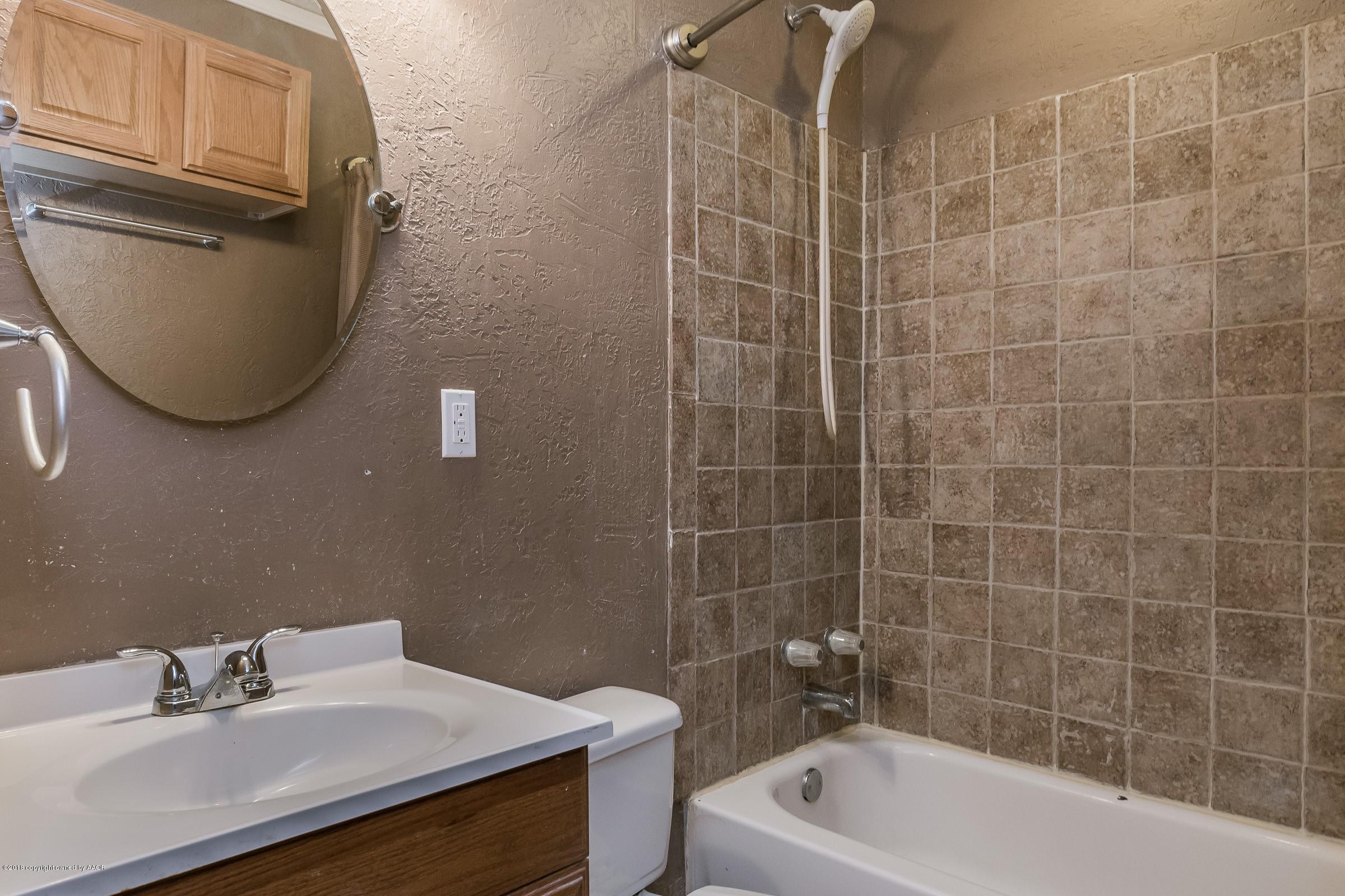 4215 South Harrison Street Amarillo, TX 79110 - Photo 4 of 15 a bathroom with a sink mirror toilet and bathtub