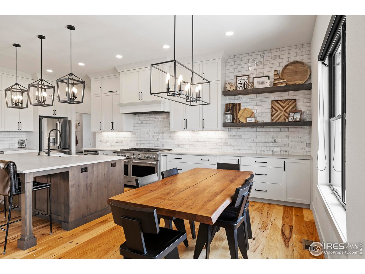37179 Soaring Eagle Circle Severance, CO 80550 - Photo 14 of 40 a kitchen with stainless steel appliances granite countertop a stove a sink dishwasher and white cabinets with wooden floor