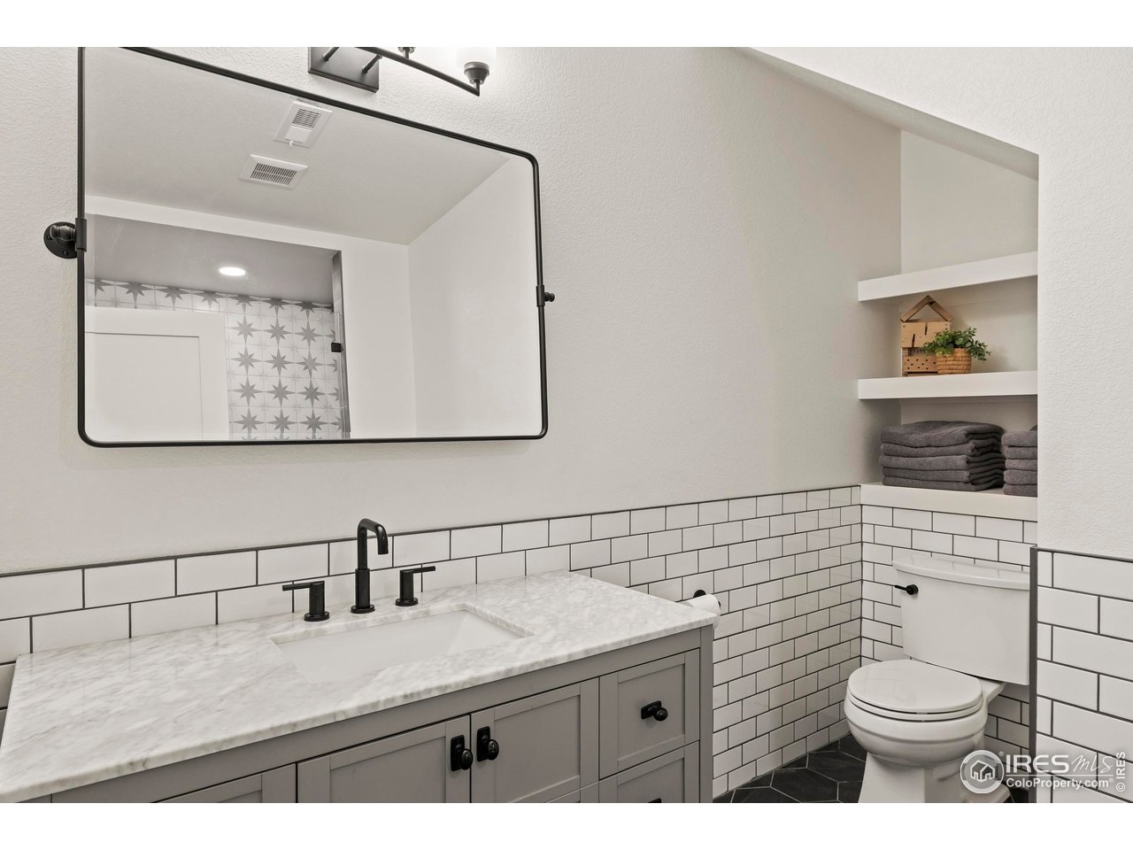 37179 Soaring Eagle Circle Severance, CO 80550 - Photo 34 of 40 a bathroom with a granite countertop sink mirror and toilet