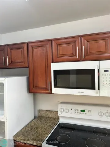 a bathroom with a granite countertop bathtub shower and toilet