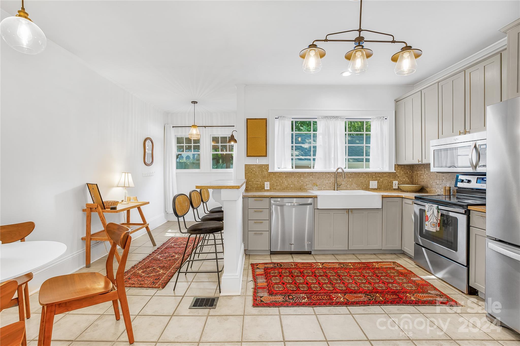 2135 Scott Avenue Charlotte, NC 28203 - Photo 23 of 48 a open kitchen with stainless steel appliances granite countertop a stove top oven a dining table and chair with the bookshelf