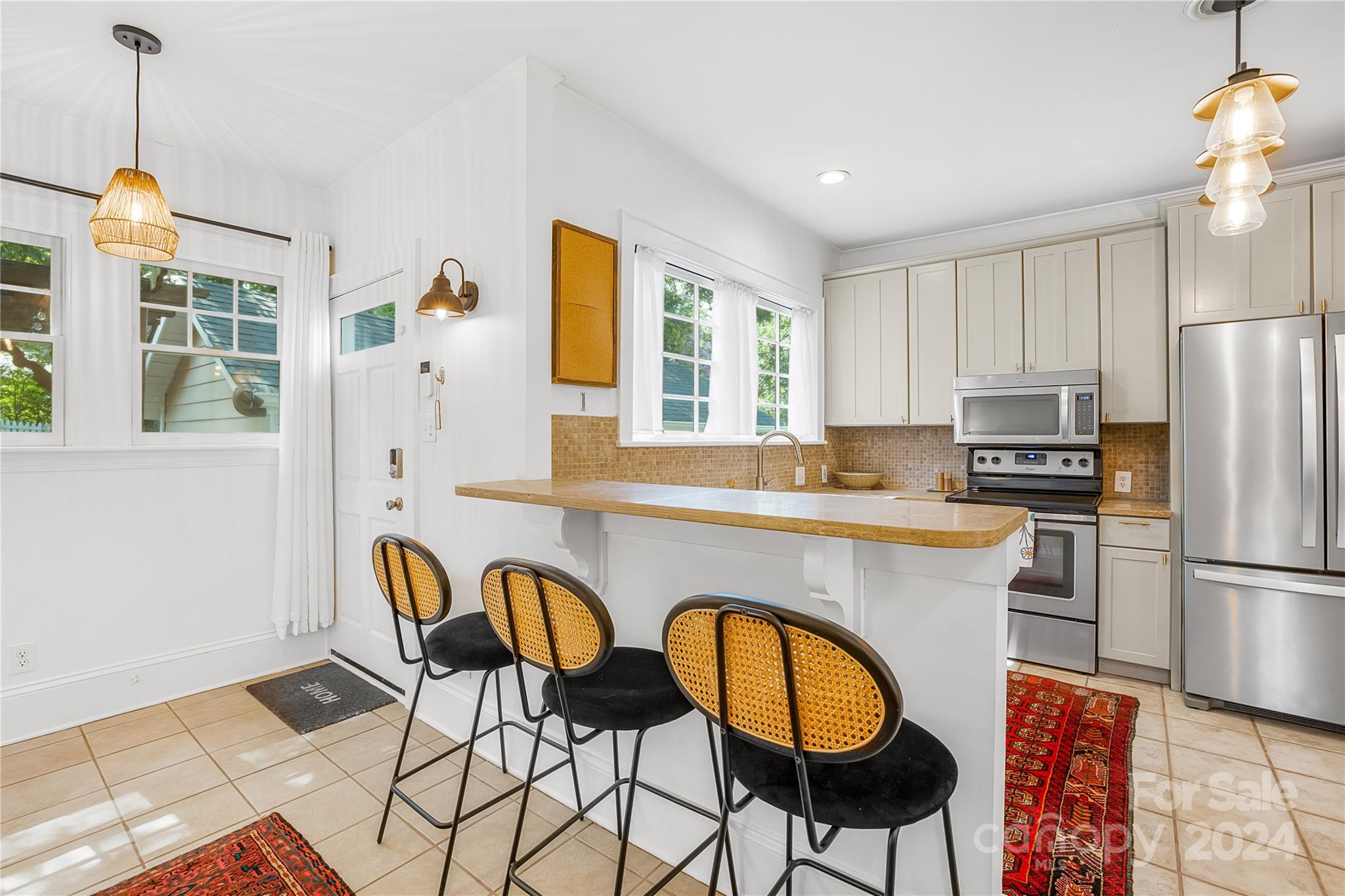 2135 Scott Avenue Charlotte, NC 28203 - Photo 26 of 48 a kitchen with stainless steel appliances granite countertop a dining table chairs refrigerator and sink