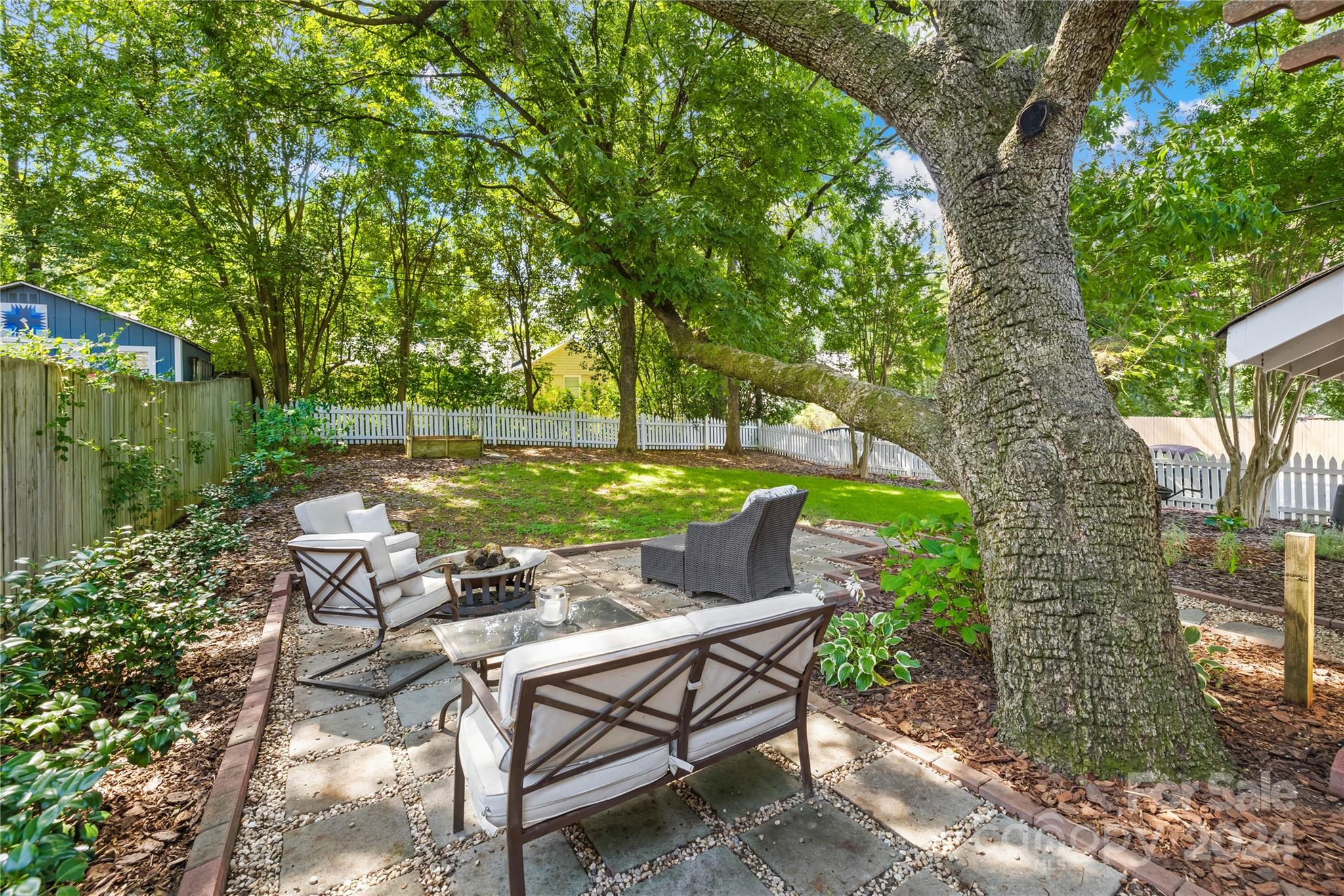 2135 Scott Avenue Charlotte, NC 28203 - Photo 41 of 48 a view of a patio with table and chairs potted plants and large tree