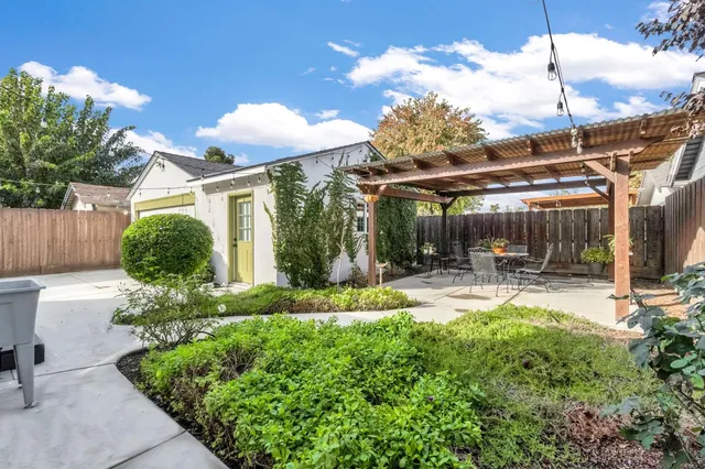 a view of a house with backyard and sitting area
