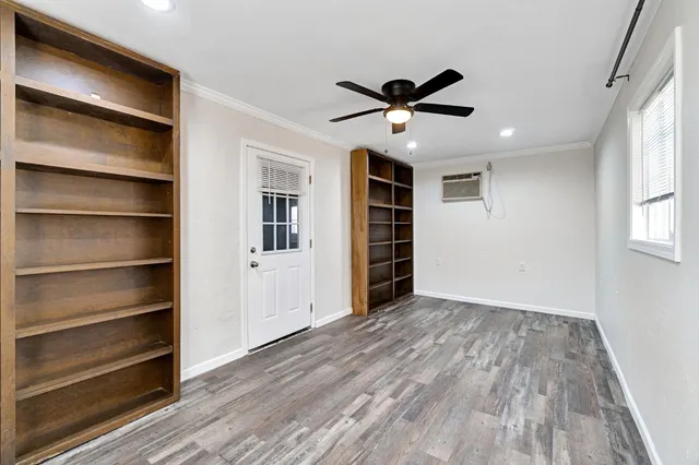 a view of empty room with wooden floor and window
